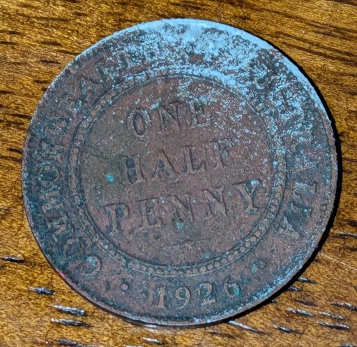 A rusted coin reading "one half penny" and "1926"
